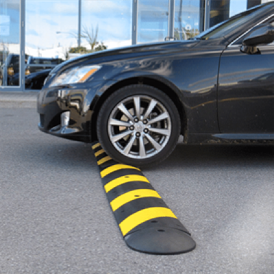 A car crossing a yellow and black speed bump