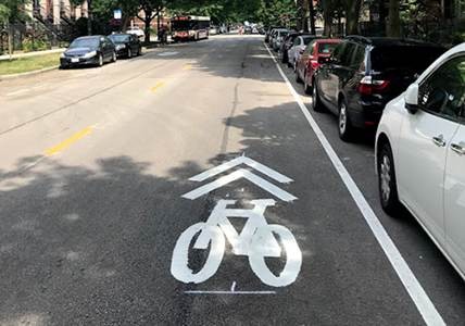 Sharrow indicating bicycles and cars share this street