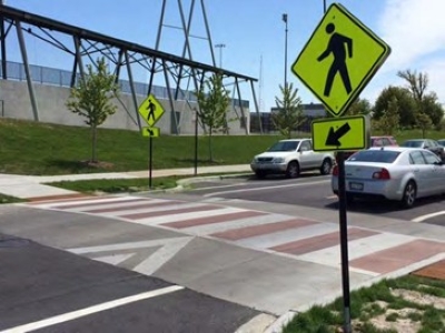 A raised crosswalk with pedestrian warning sign